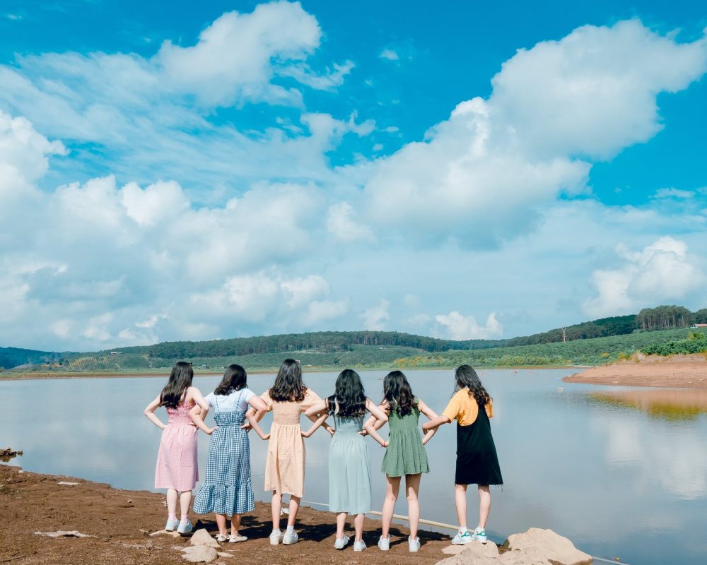 group of girls standing beside river